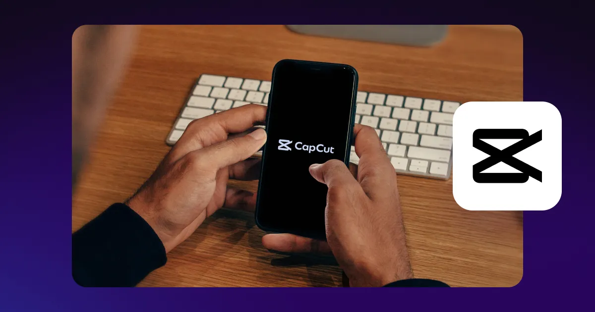 A hand holding a phone displaying CapCut’s interface with the app's logo at the side.