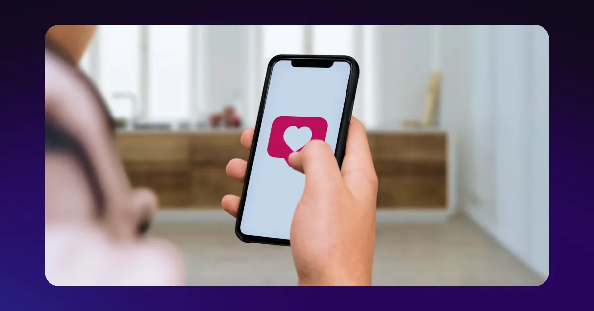 A hand holding a phone with a “like” logo and various plants and notebooks on the left.