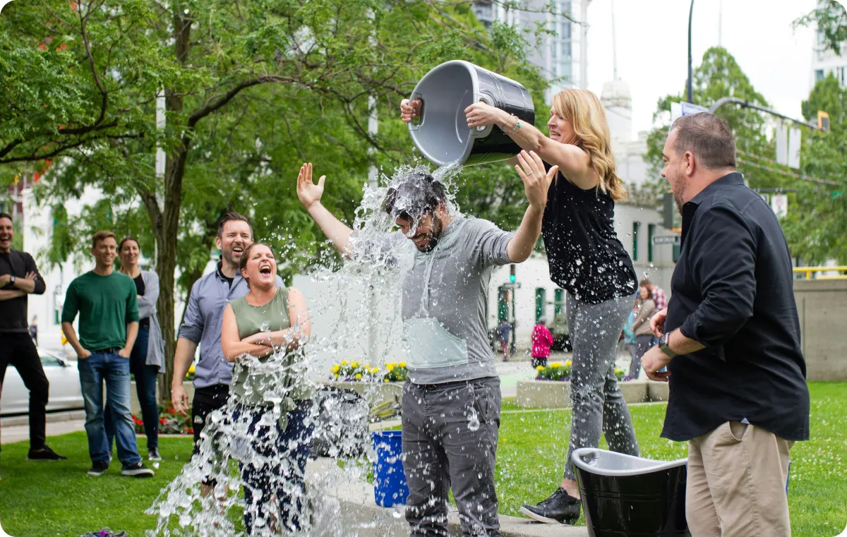 A group of people doing the ice bucket challenge outdoors.
