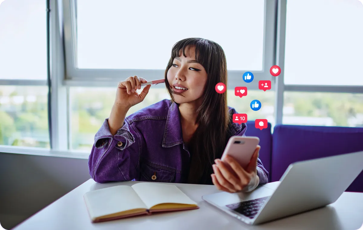 A person using a phone with various icons representing social media metrics floating around.