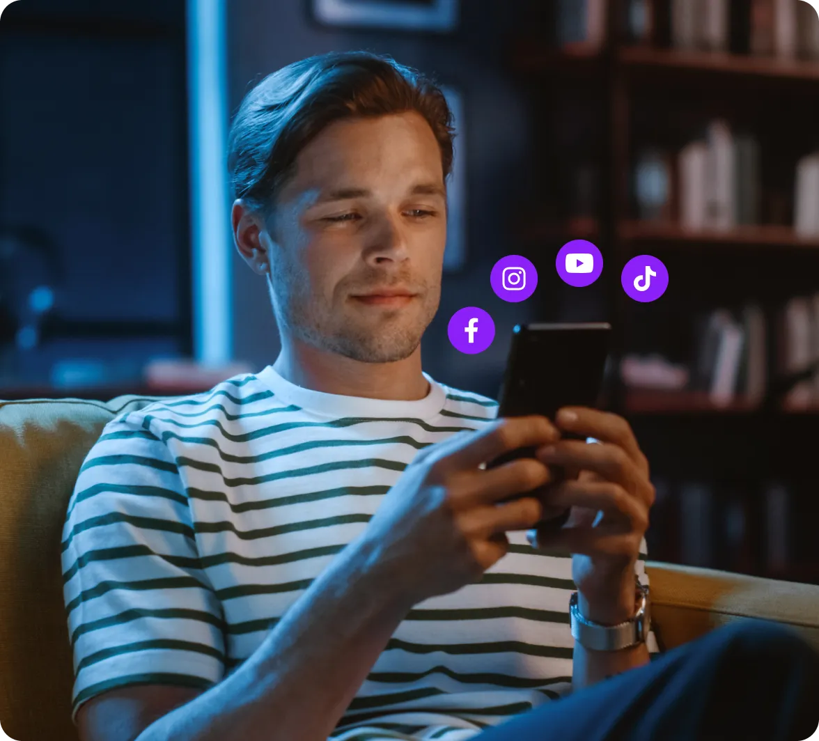 Um criador usando um telefone com logotipos de mídia social circulando.