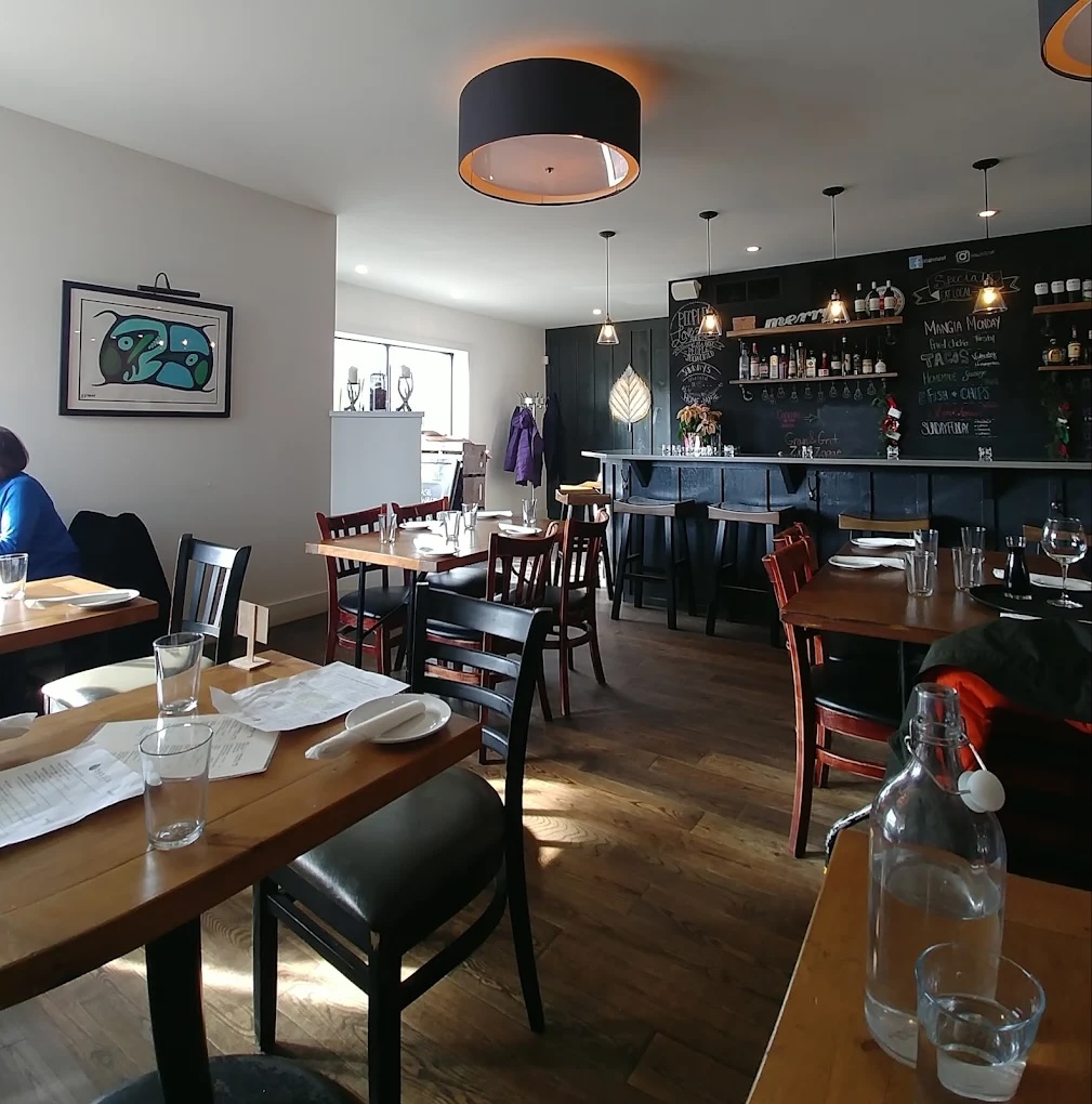 The inside of Betula–a dining room with wooden tables and floors, white walls and black trim