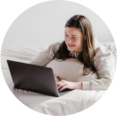 patient sits in bed smiling on a video call