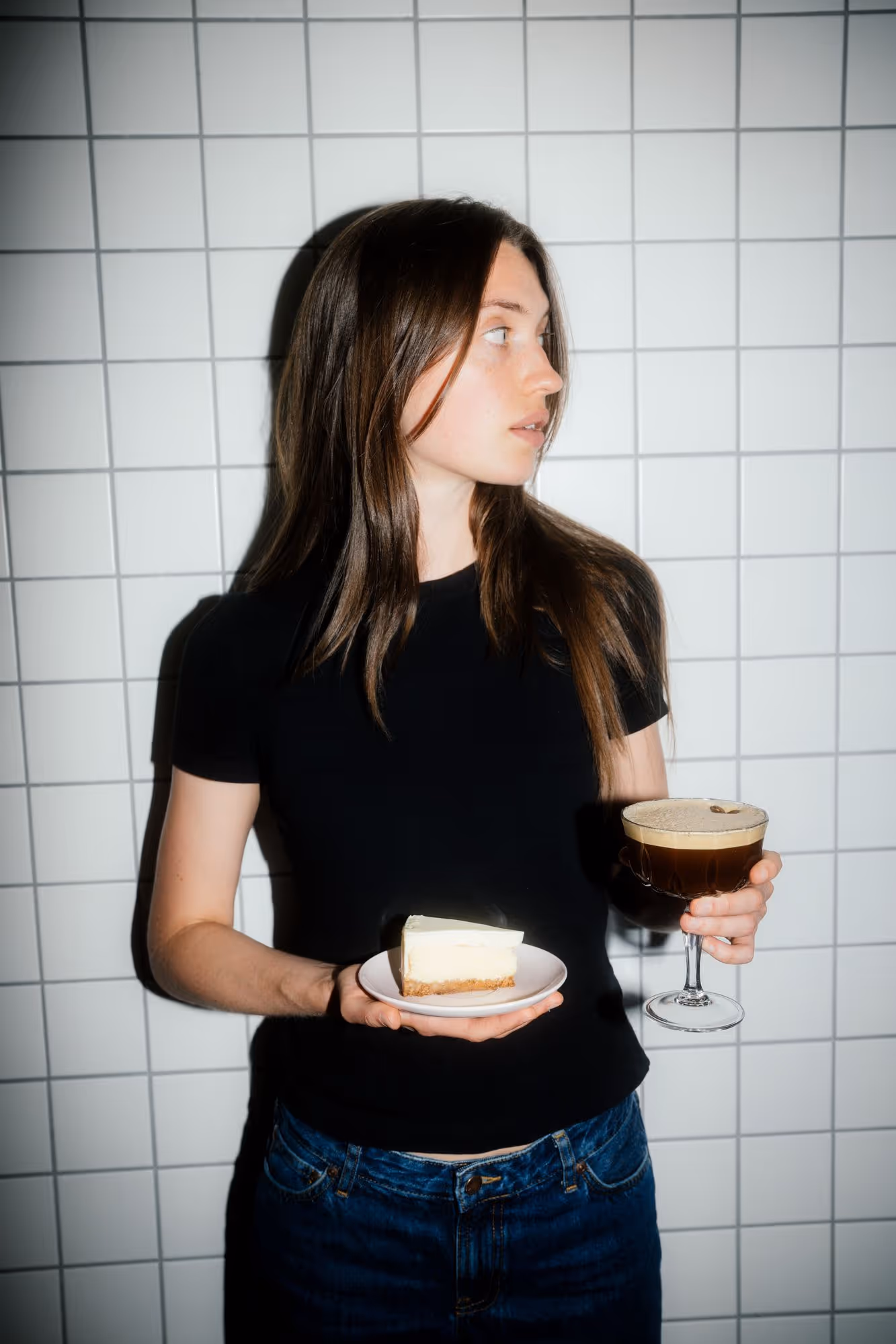 a woman holding a plate of coffee and a slice of cake