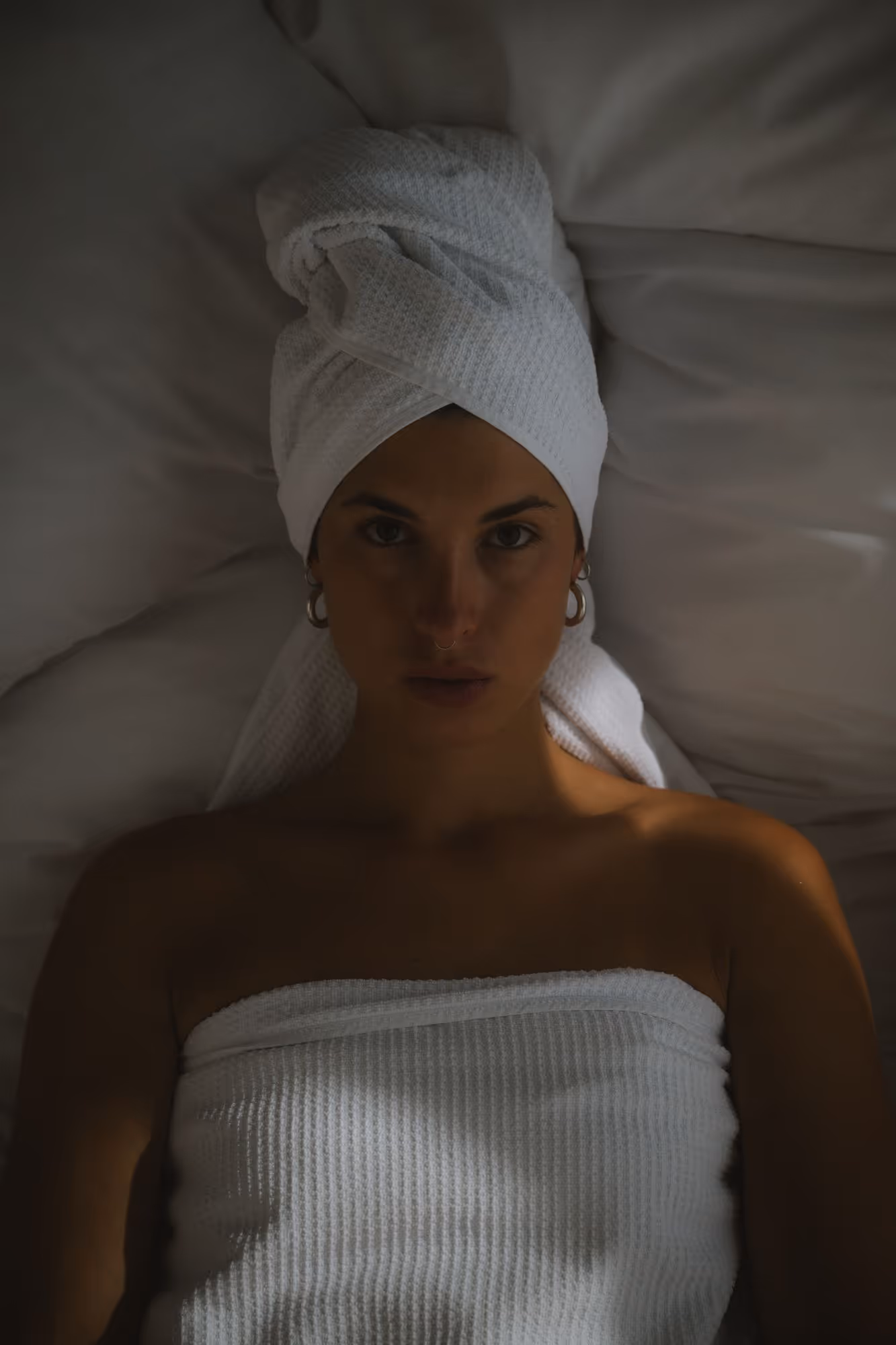 a woman lying down with a towel on her head