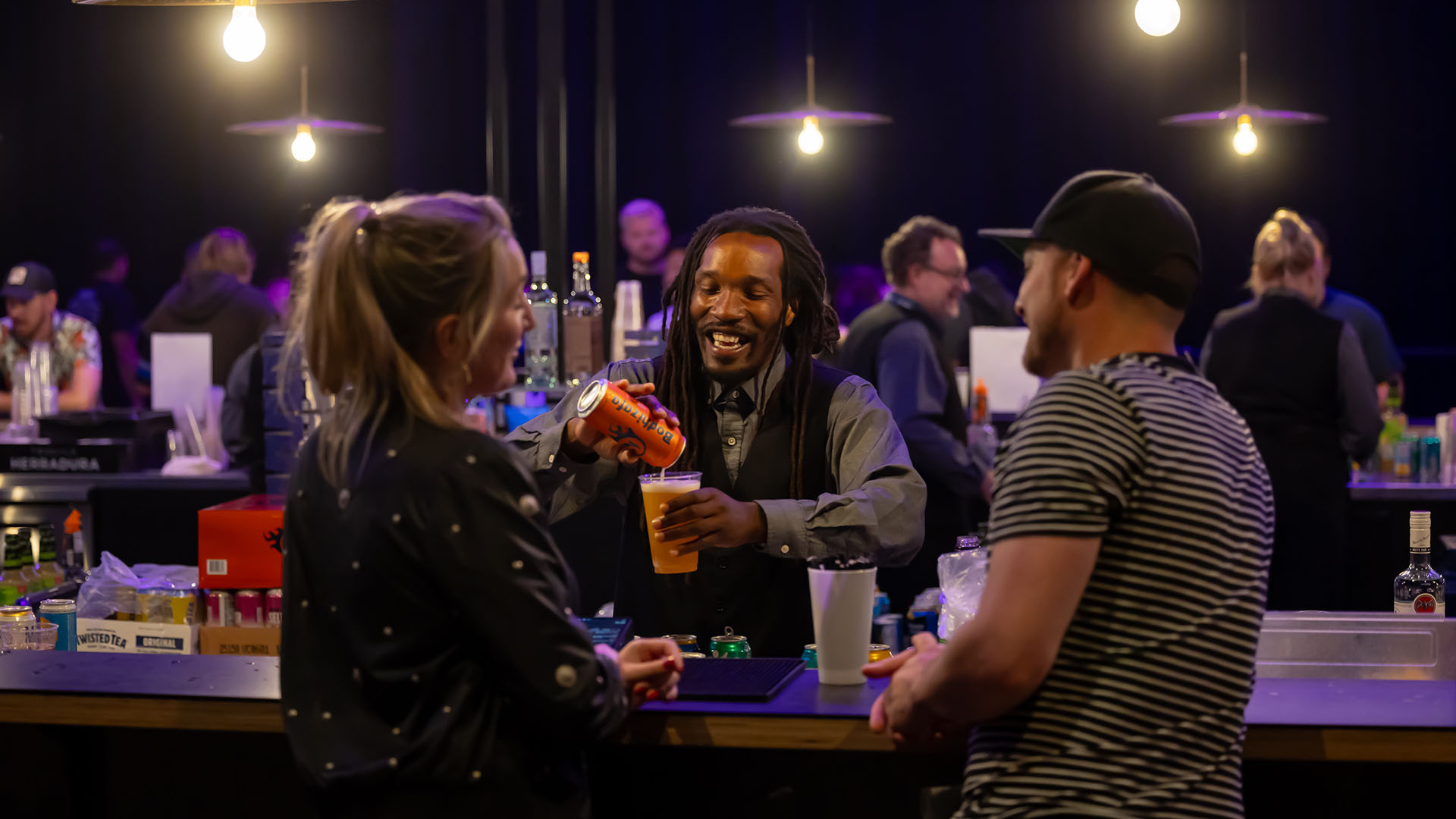 An image of two WAMU theater guests laughing with a bartender and enjoying the bar