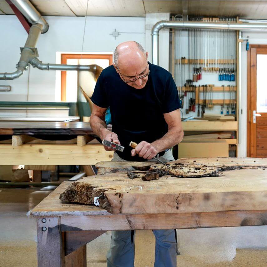 Master carpenter Michael Beaupoil in workshop with quality workmanship of incomparable wooden table