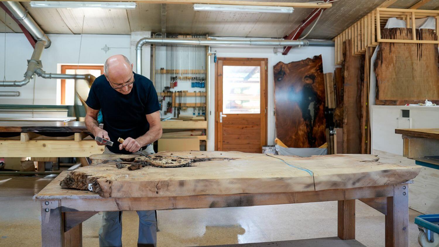 Master carpenter Michael Beaupoil working on a special table top for a unique wooden table made from Kauri root wood