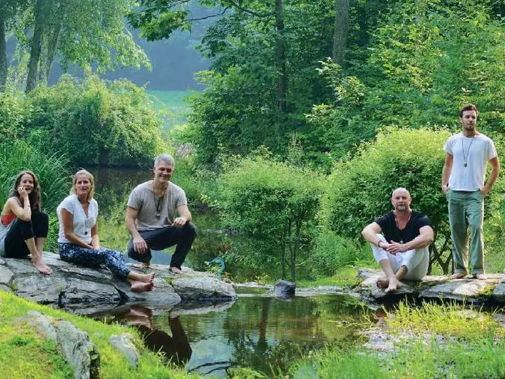 Retreat guests relaxing by a pond in the English countryside