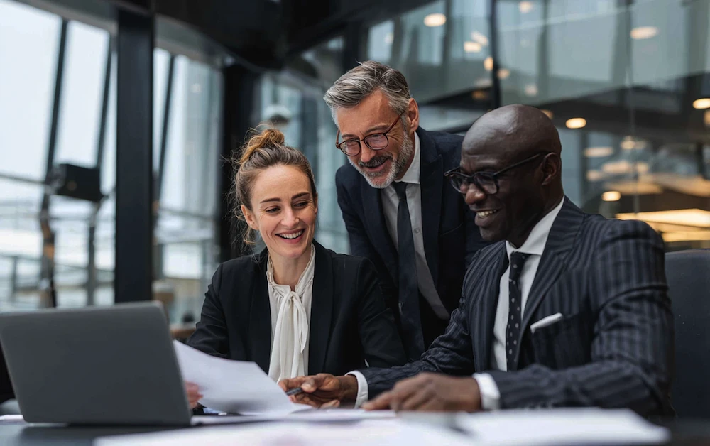 Team of financial professionals discussing accounting issues and reviewing documents together in a modern corporate office.