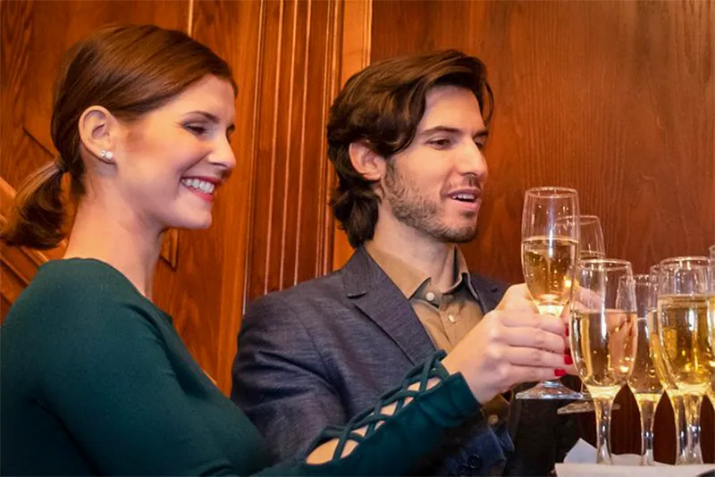 Mężczyzna i kobieta siedzą przy stole z kieliszkami wina