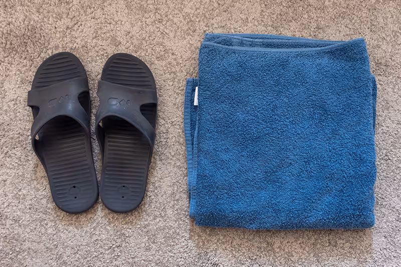 A pair of slippers and a towel on the floor