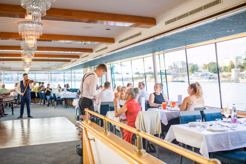 En gruppe mennesker sitter ved bordene i en restaurant