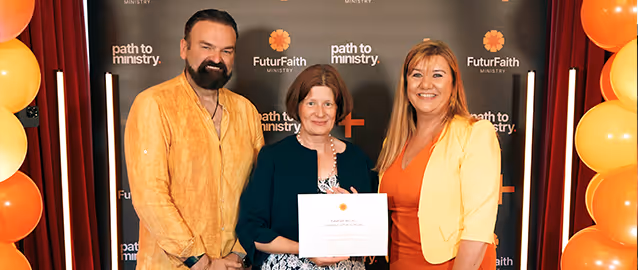 Three smiling adults standing in front of a backdrop with 'FuturFaith Ministry' and 'path to ministry' logos, one holding a certificate, surrounded by orange and yellow balloons.