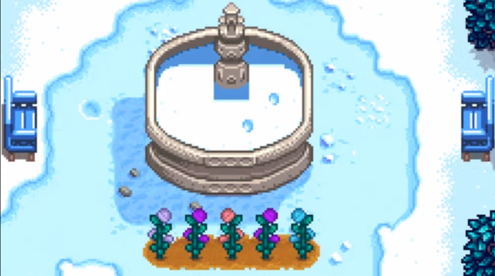 Fairy roses growing in front of the community center fountain in stardew valley during winter