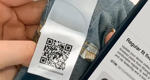 A smartphone has scanned a QR code on a pair of trousers and is displaying the product information