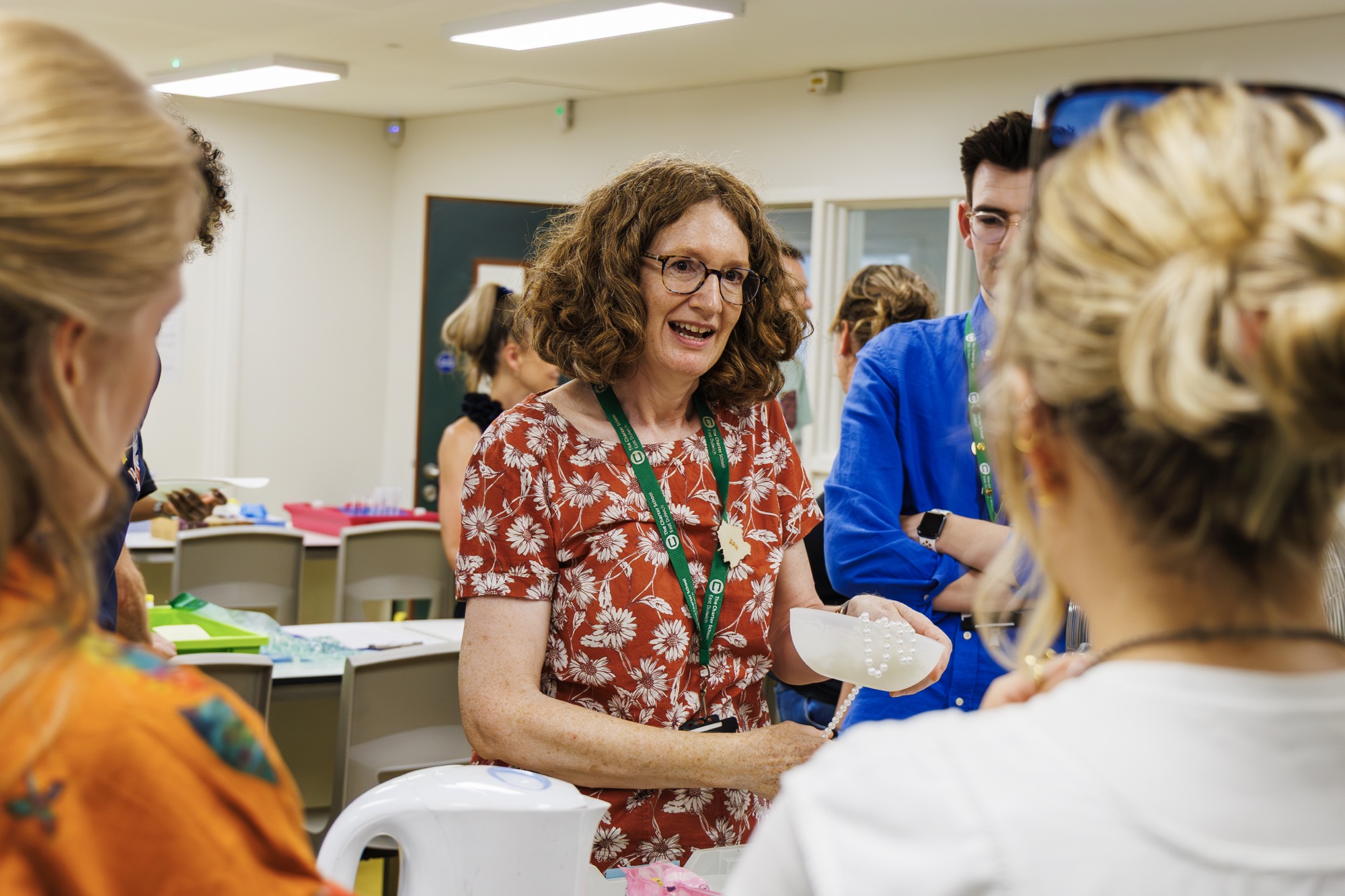 A smiling educator takes part in a hands-on workshop with colleagues at a training event.
