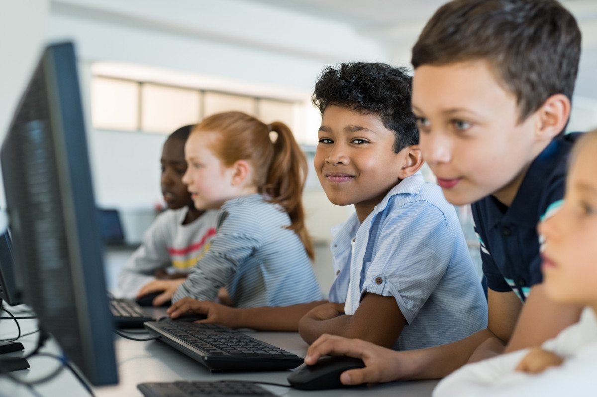 Students smiling and learning on computers