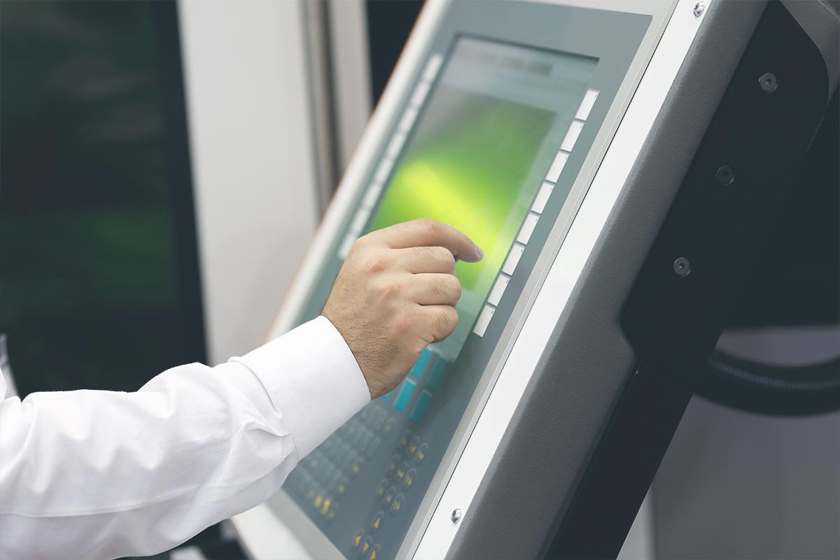 Automatisierte Verpackungsmaschine legt Kartons auf ein Förderband in einer Fabrik.
