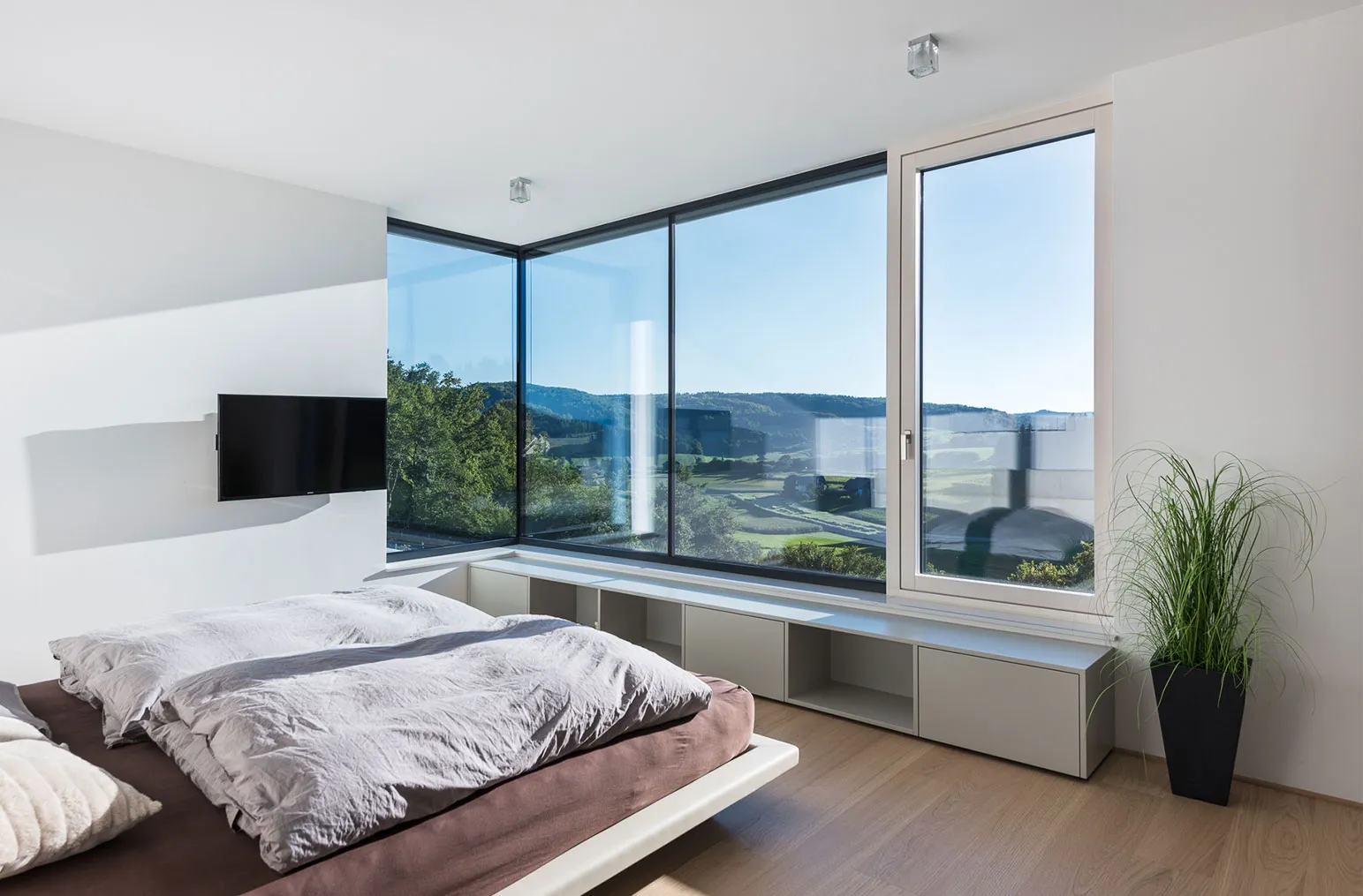 Ein lichtdurchflutetes Zimmer mit großen Fenstern.