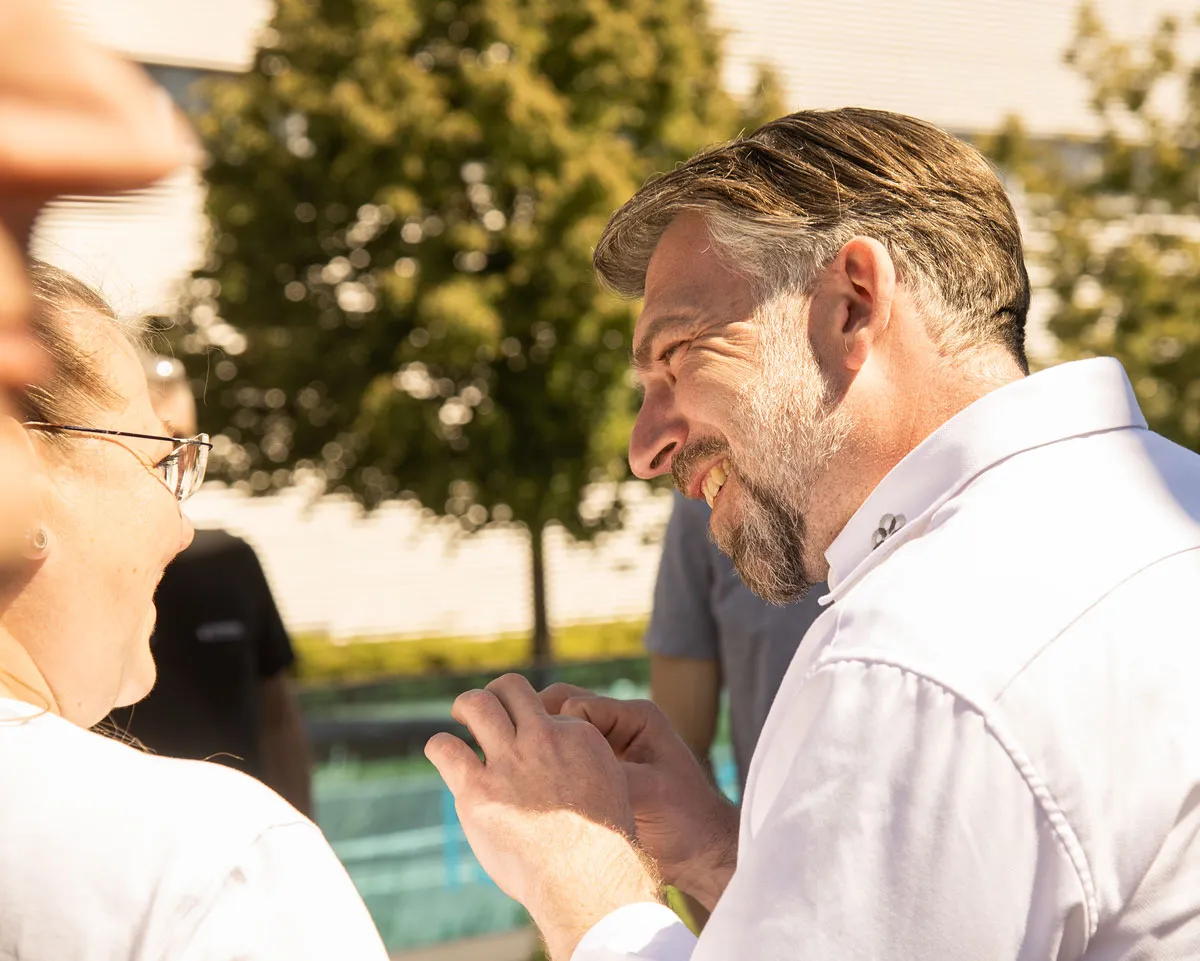 Ein Mann der sich mit einer Frau unterhält und lächelt.