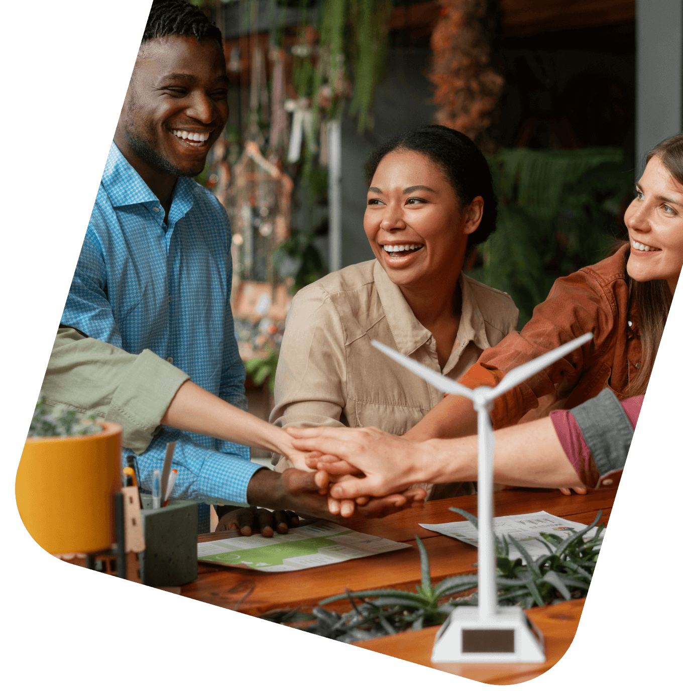 Grupo de colaboradores sorridentes unindo as mãos em sinal de cooperação e parceria, simbolizando o impacto social positivo da Quansa nas empresas.