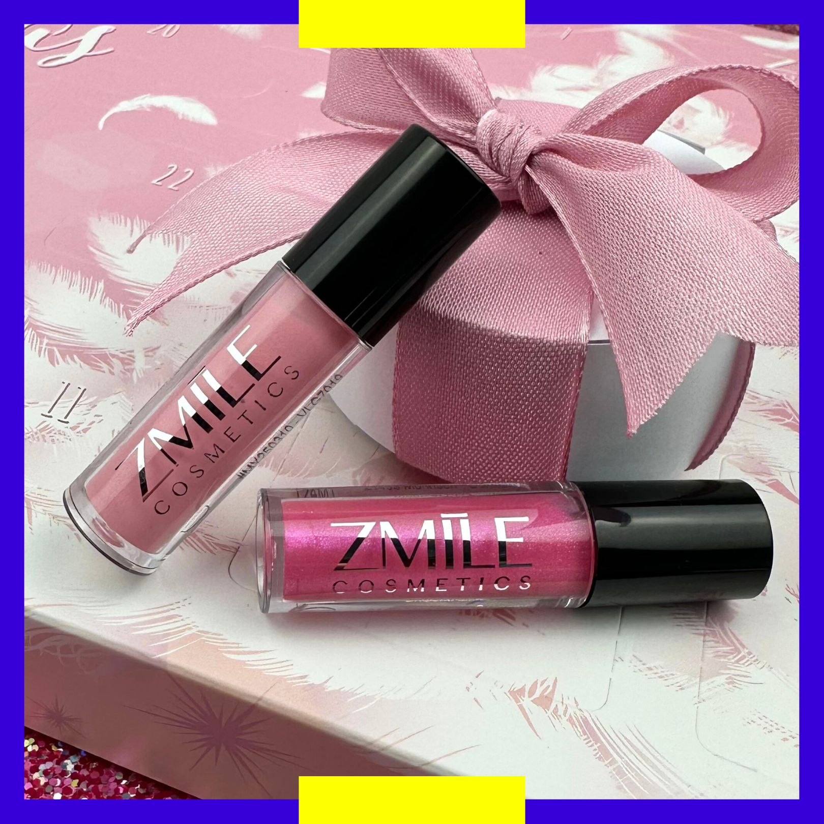 Zwei Lipgloss in Pink und Nude aus dem ZMILE Cosmetics Adventskalender Pink and Fluffy, drapiert mit kleinem Geschenk.