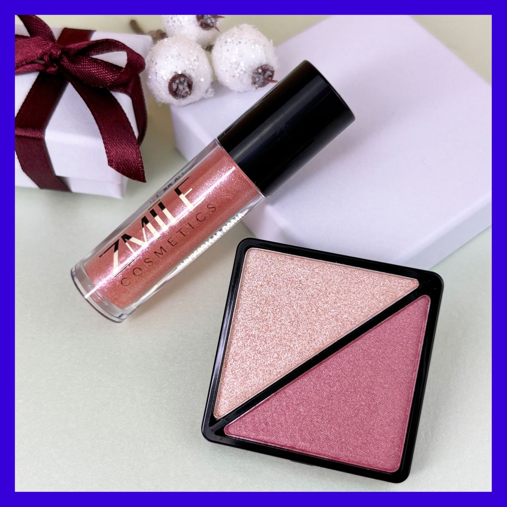 Funkelnder Highlighter und berry Blush im quadratischen Case mit schimmerndem Lipgloss aus dem ZMILE Cosmetics Adventskalender Jingle and Glow, drapiert mit kleinem Geschenk.