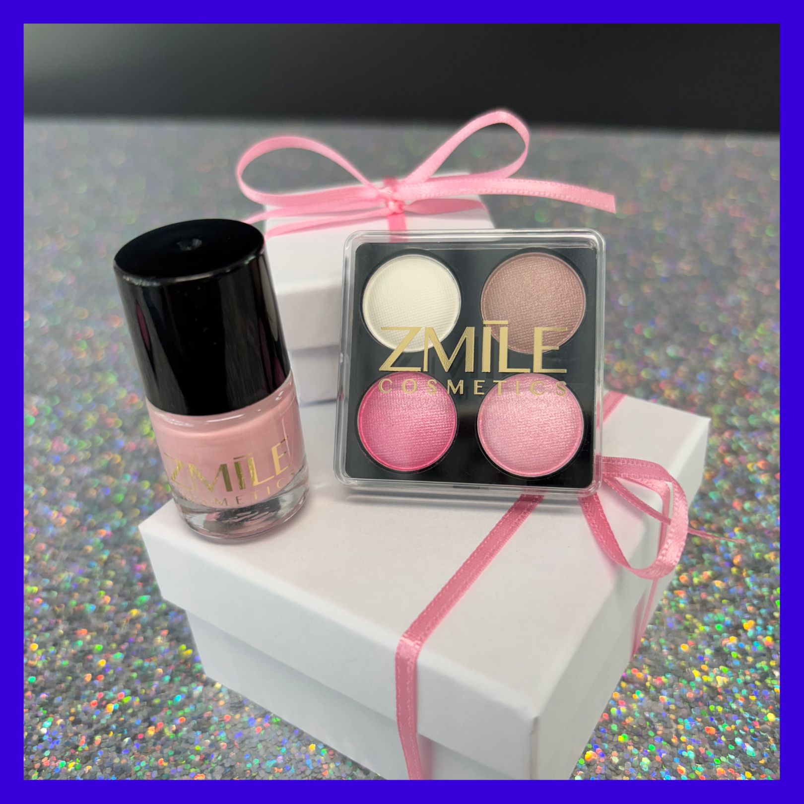 Vierer-Lidschatten und rosa Nagellack mit ZMILE Cosmetics Aufdruck, platziert auf weißen Geschenkboxen und Glitzer-Untergrund.