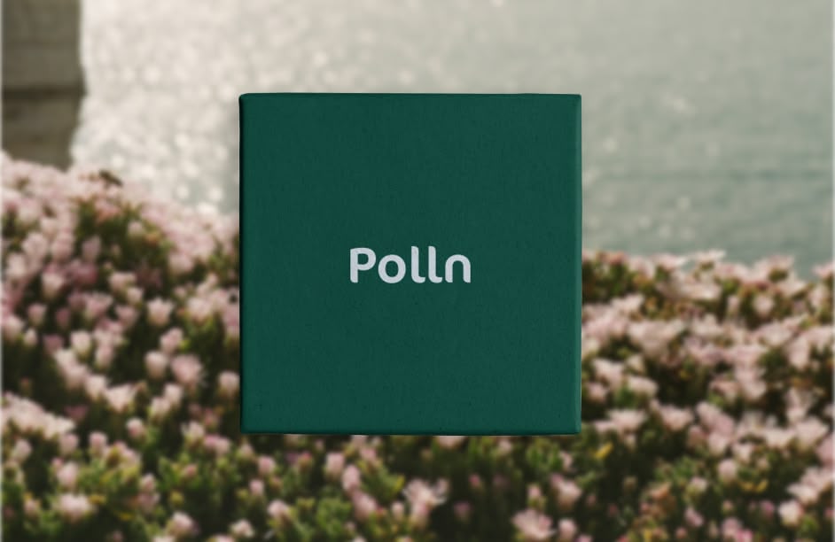 Green box with the word 'Polln' on it, placed over a blurred background of pink flowers and water.
