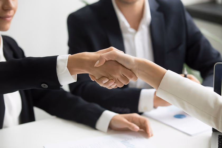 Business partners shaking hands while signing a contract