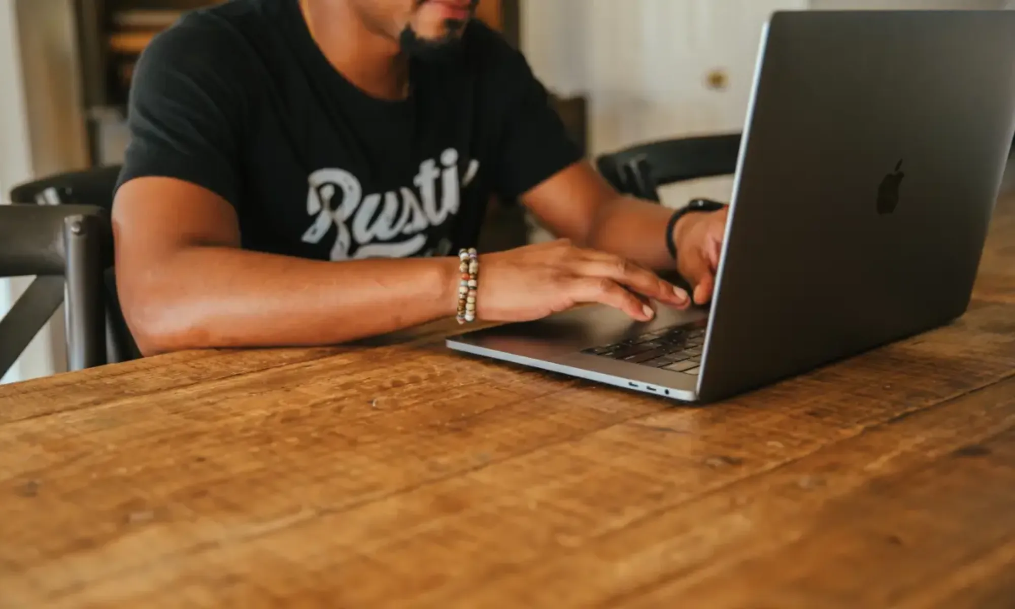 a man sitting at a table using a laptop computer