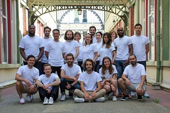 équipe pédagogique en t-shirts blancs réunie dans un couloir sous une verrière lors d’un atelier data science