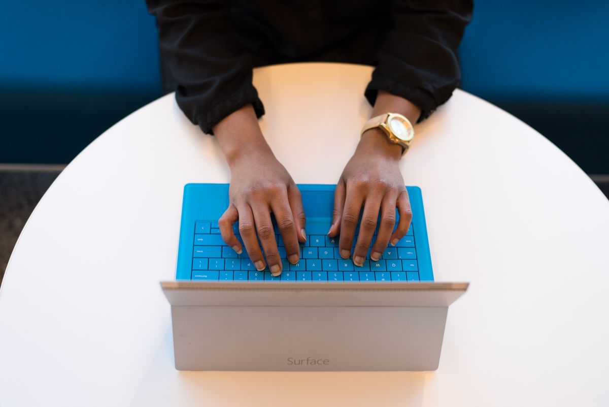 Mains tapant sur un clavier d'ordinateur portable