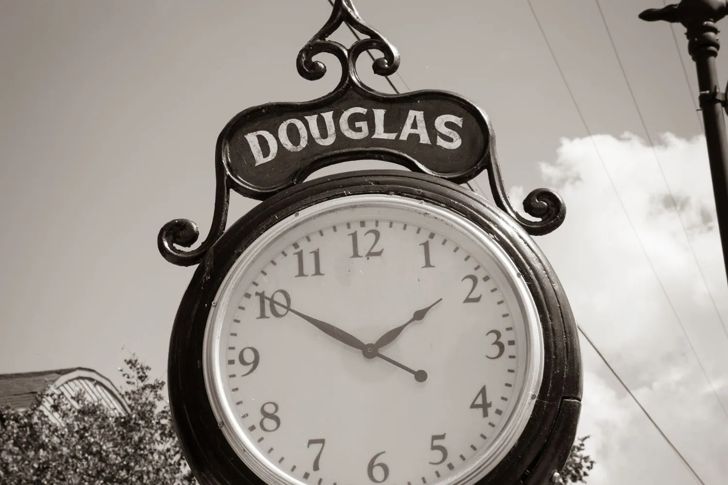 Black street clock showing 1:50 with the word DOUGLAS on top.