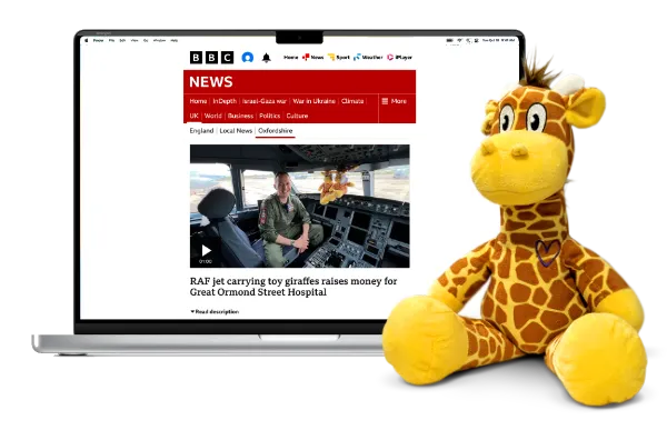Giraffe's on Tour, bespoke plush and a laptop showing the news article.