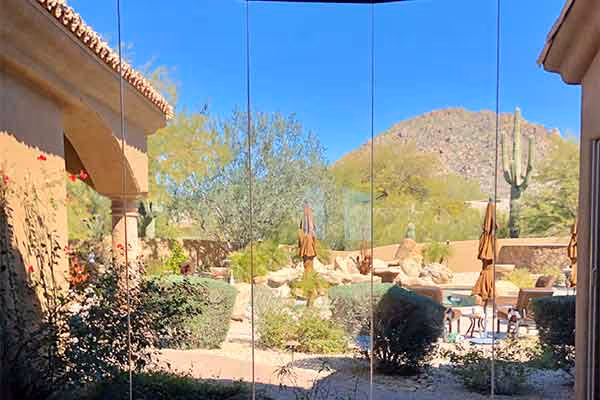 A stunning glass windows view of the sunny home backyard surrounded by desert landscape in Cave Creek Arizona, maintained with pure water window cleaning by a great company.