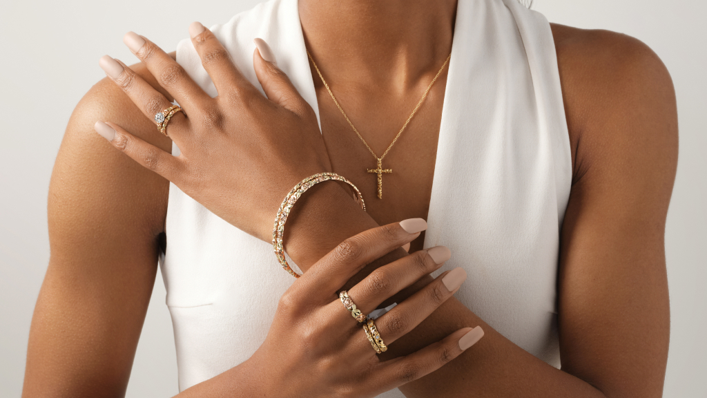 A woman wearing a gold bracelet and necklace