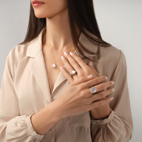 A woman wearing matching rings and necklace