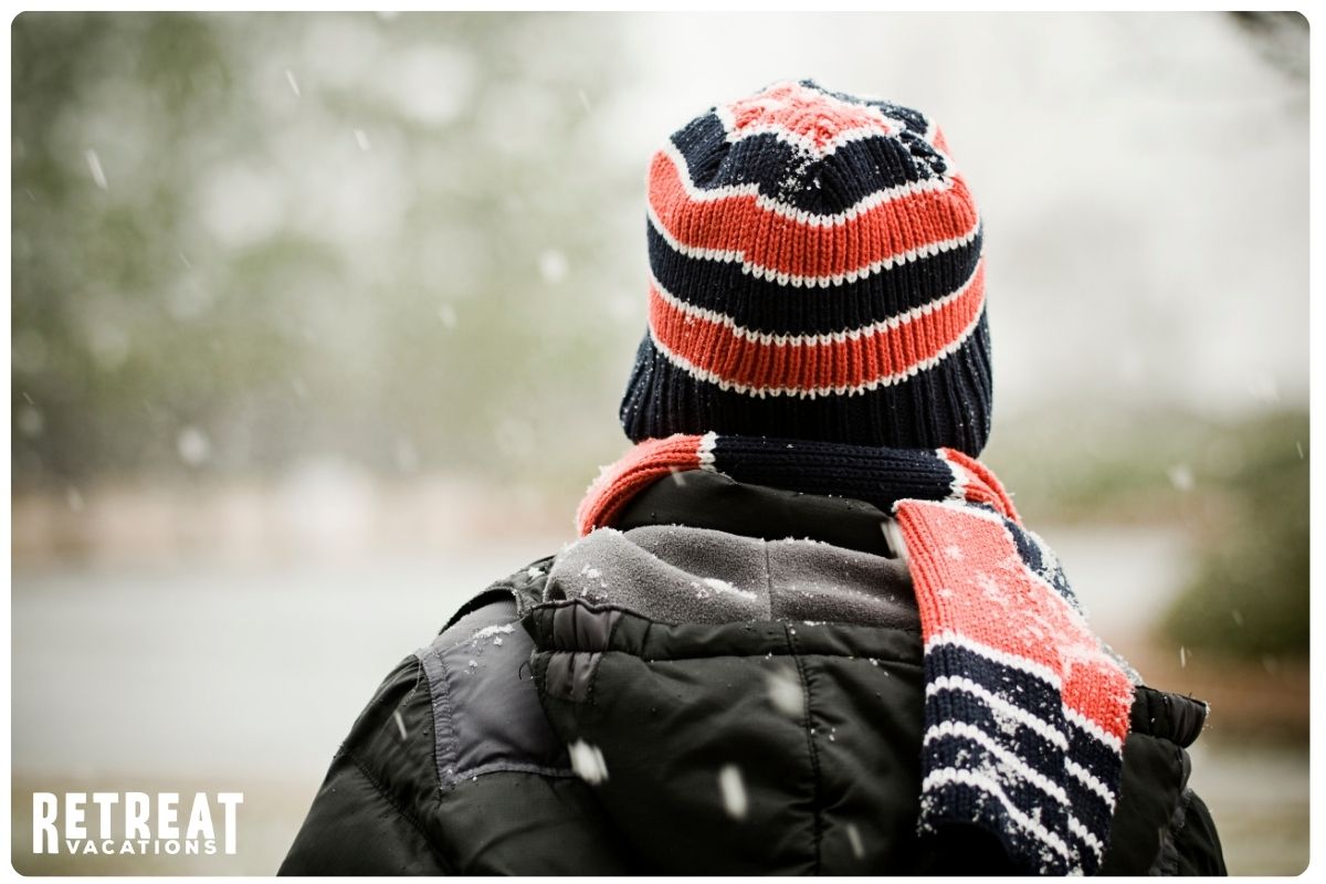 Close-up of person wearing a warm scarf and hat, adding a cozy, seasonal feel for fall and winter packing essentials at The Retreat by Oakstone.