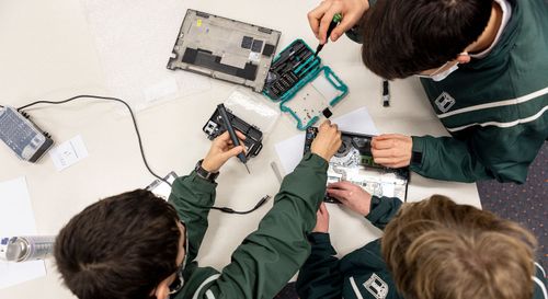 School students work on reviving digital devices.