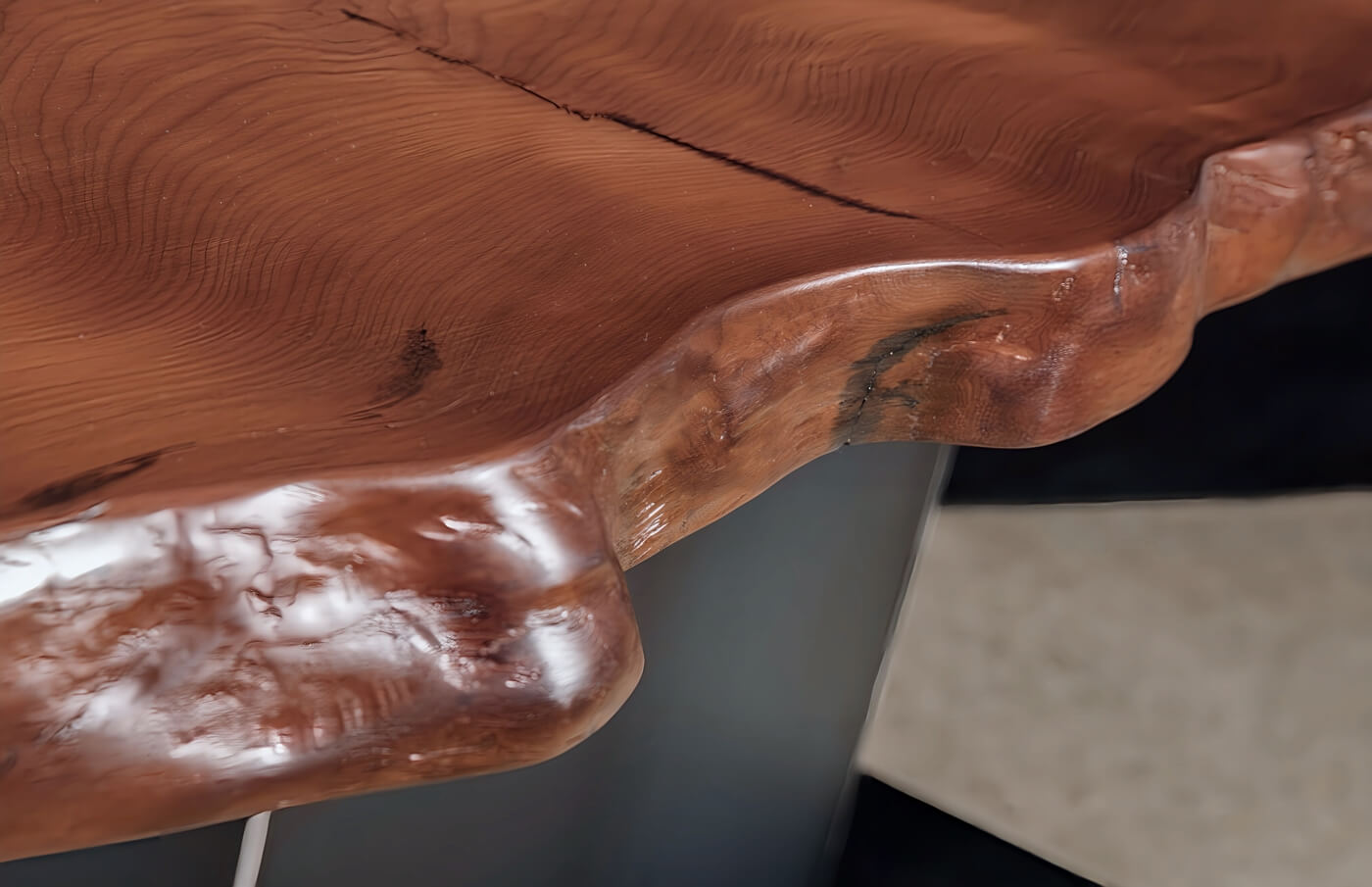 A distinctive, natural-edged tabletop with a soft, smooth texture, crafted from reclaimed wood, for a unique designer dining table suited to exclusive design interiors