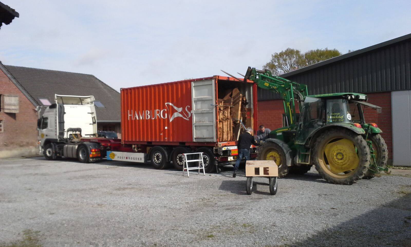 Des plateaux de table en kauri et une grande racine provenant de Nouvelle-Zélande sont déchargés du conteneur.