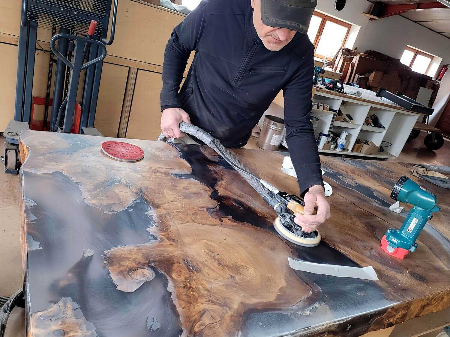 Tischlermeister Michael Beaupoil beim Bearbeiten einer hochwertigen Tischplatte mit Holz, Rinde, Harz, Bernstein eines besonderen Designtisches