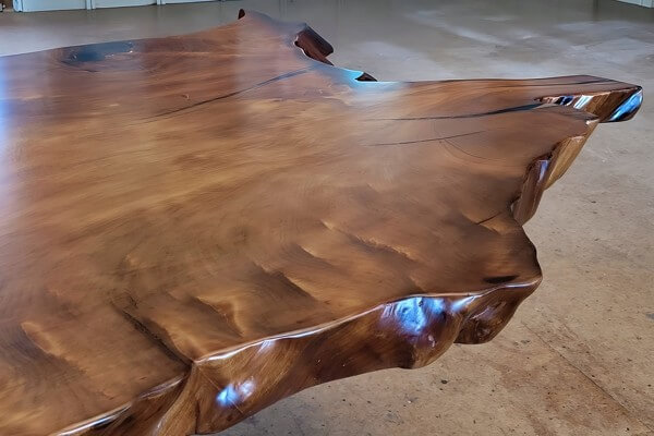 Handgefertigte Tischplatte aus altem Kauri Baumstammholz mit Baumkanten eines exklusiven Esstisches