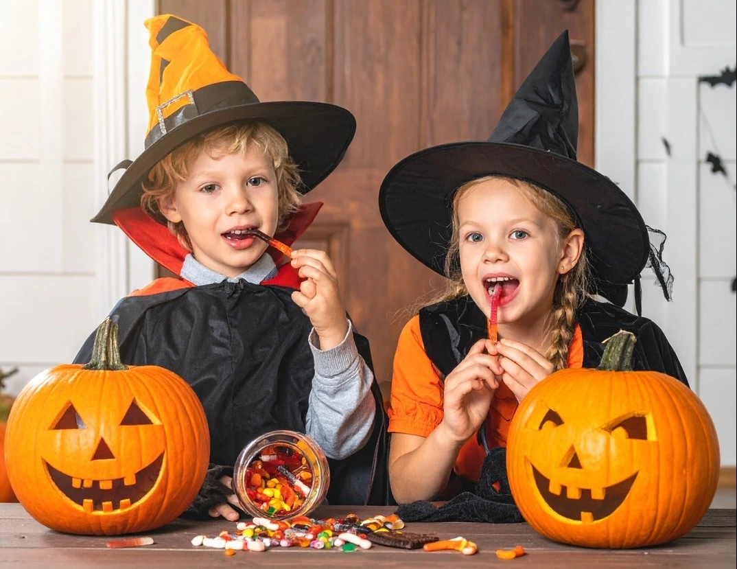 Smiling children enjoying Halloween candy while maintaining healthy teeth with tips from Main Street Dental in Vista, CA.