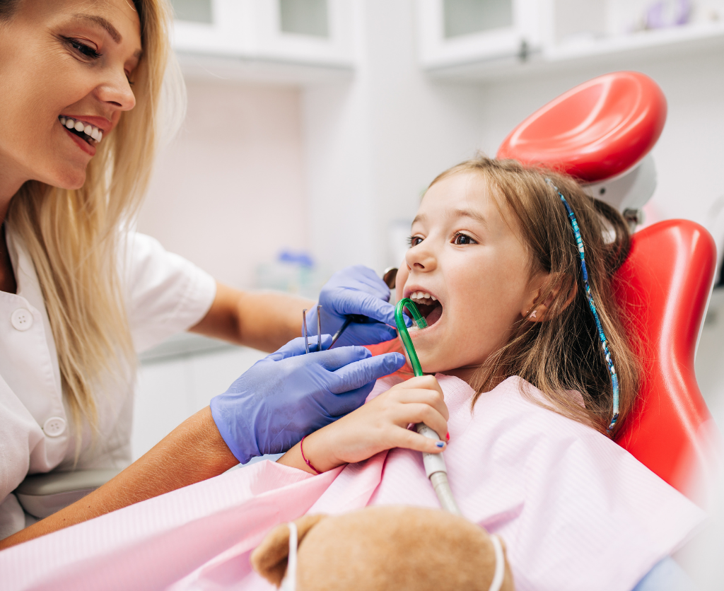 Happy children smiling during a dental checkup at Main Street Dental, showing positive dental experiences.
