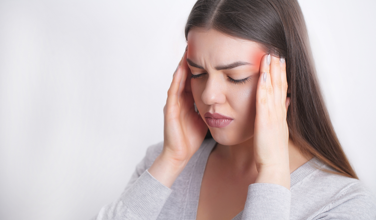 Close-up of a young adult holding their jaw in discomfort due to wisdom teeth pain.