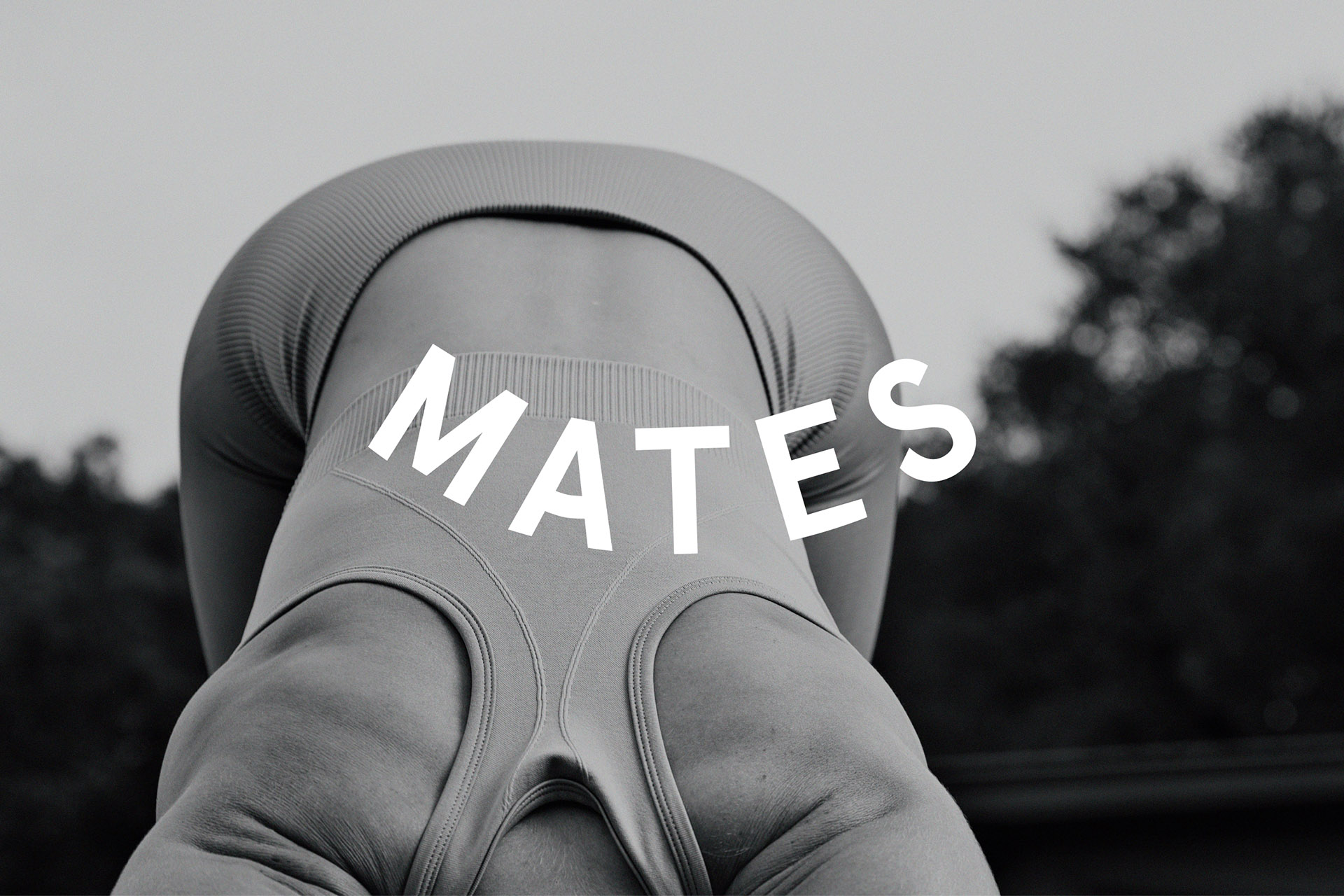 Logo of mates overlayed over womans back doing yoga
