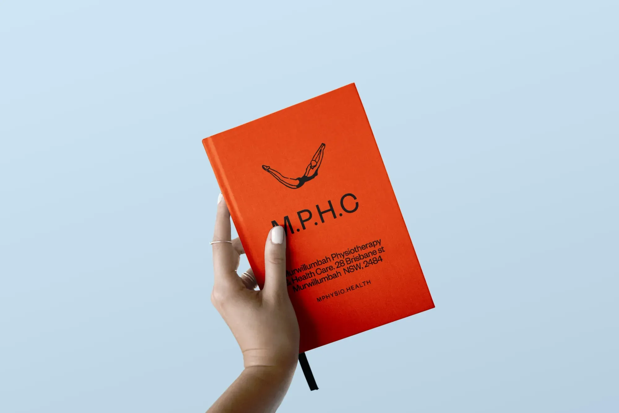 Hand holding murwillumbah branded book 
